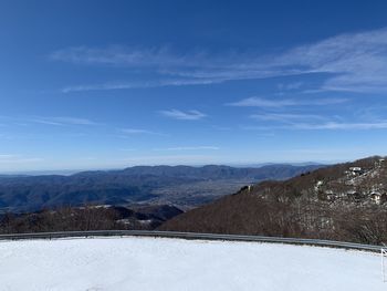 Scenic view of snowcapped mountains against blue sky