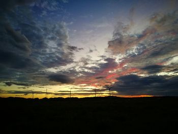 Silhouette landscape against dramatic sky during sunset