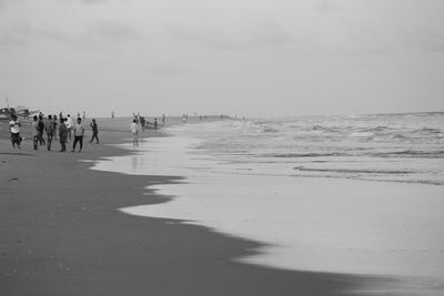 People on beach against sky