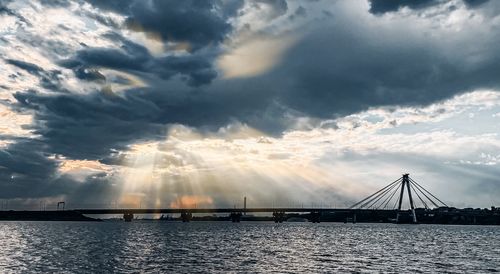 Bridge over sea against sky during sunset