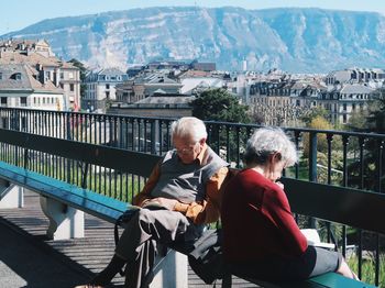 Men sitting on railing in city