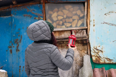 Low angle view of woman standing against wall