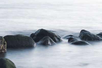 Rocks in sea against sky
