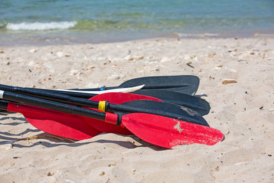 Close-up of shoes on sand at beach