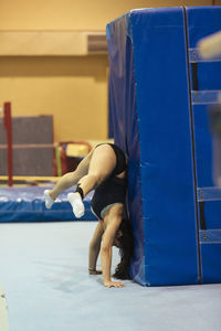 Side view of young woman exercising at gym