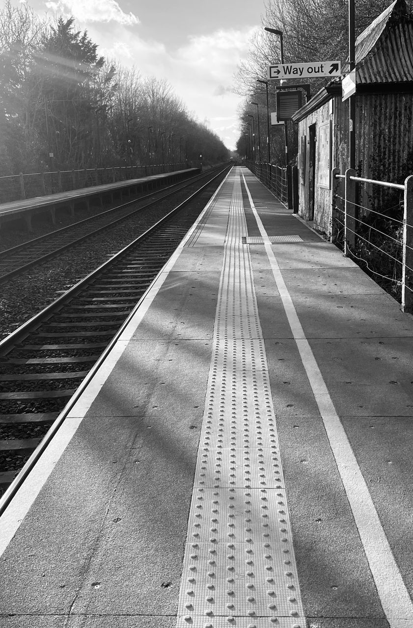 black and white, lane, track, transportation, monochrome, railroad track, the way forward, transport, rail transportation, monochrome photography, line, road, diminishing perspective, sky, vanishing point, nature, architecture, no people, white, tree, day, built structure, outdoors, railway, cloud, plant, travel, mode of transportation, black, railroad station, public transportation, railroad station platform