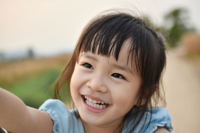 Close-up of cute smiling girl looking up