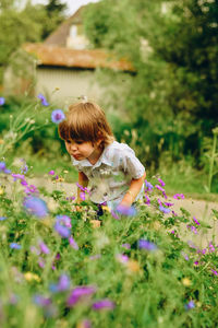 Rear view of woman with pink flowers on land