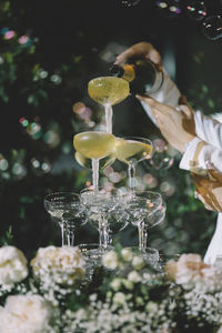 Close-up of hand pouring wine in glass on table