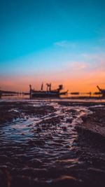 Surface level shot of sea against dramatic sky during sunset