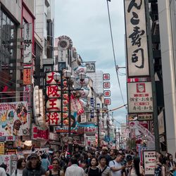 People on street amidst buildings in city