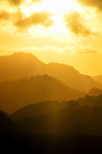 Scenic view of silhouette mountains against orange sky