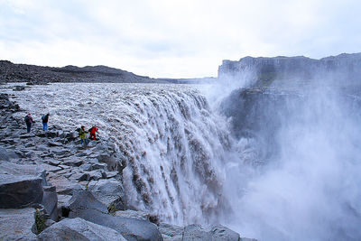 Scenic view of waterfall against sky