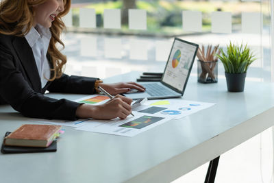 Midsection of business people working on table