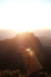 A man is standing on the peak of the mountain