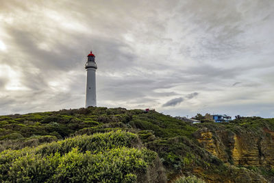 Low angle view of lighthouse amidst buildings against sky