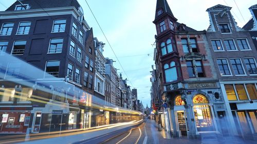 Road amidst buildings against sky in city
