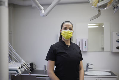 Female dentist standing in office