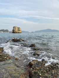 Scenic view of rocks in sea against sky