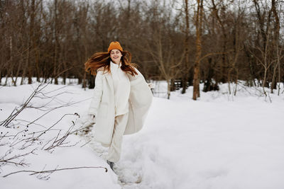 Young woman standing on snow covered field