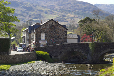 Arch bridge over river amidst buildings and mountains