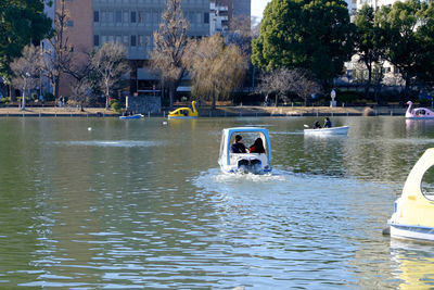 Boats in river with buildings in background