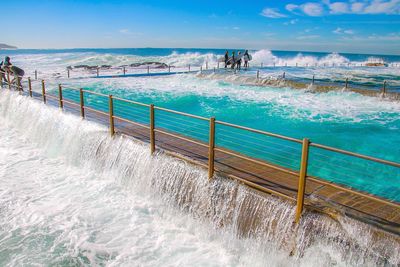 Scenic view of swimming pool by sea against sky