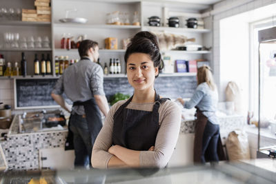 Portrait of young woman standing in front of people