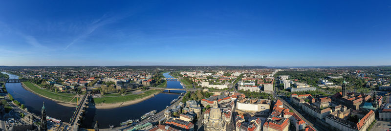 High angle view of illuminated city by river against sky