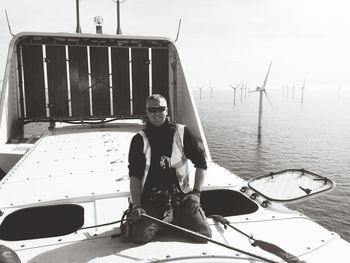 Smiling man sitting on boat in sea