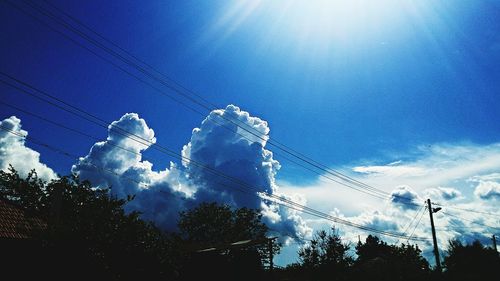 Low angle view of power lines against blue sky