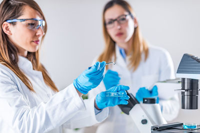 Female scientists examining chemical in laboratory