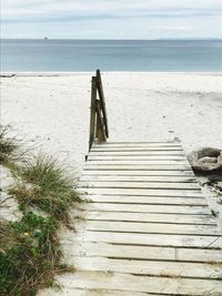 Staircase on beach against sky