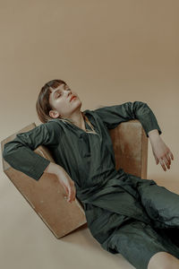 Boy sitting on floor against white background