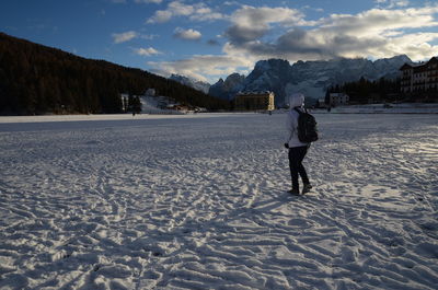 Rear view of man standing on snow covered landscape