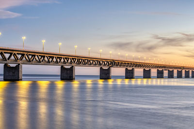 Bridge over river against sky during sunset