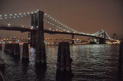 Suspension bridge over river at night