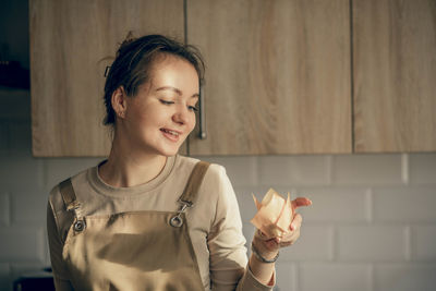 Young woman hold cupcake in a craft. birthday package. bakery chef bakes pastries in kitchen