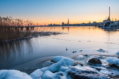 Scenic view of frozen river against sky during sunset