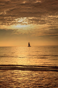 Silhouette boat in sea against sky during sunset