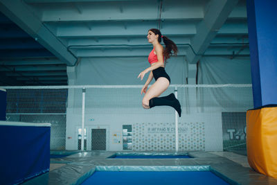 Full length of woman jumping in swimming pool