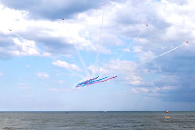 Airplane flying over sea against sky