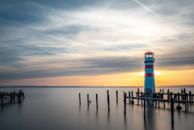 Pier over sea against sky during sunset