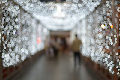 Defocused image of people in illuminated room