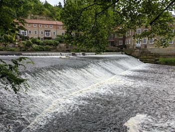 Scenic view of dam against trees in city