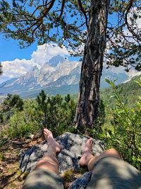Low angle view of human legs against  mountains. relaxing scene