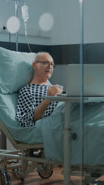 Senior patient using laptop at hospital
