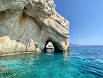 Scenic view of rock formation in sea against sky