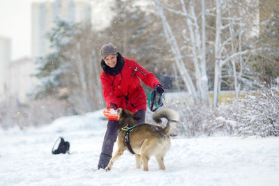 Side view of dog running on snow covered field