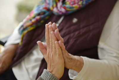 Cropped image of mother and daughter high-fiving at home